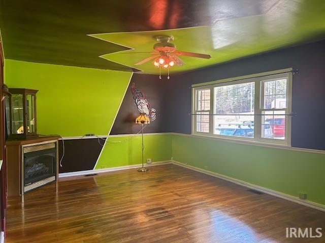 unfurnished room with baseboards, a ceiling fan, and wood finished floors