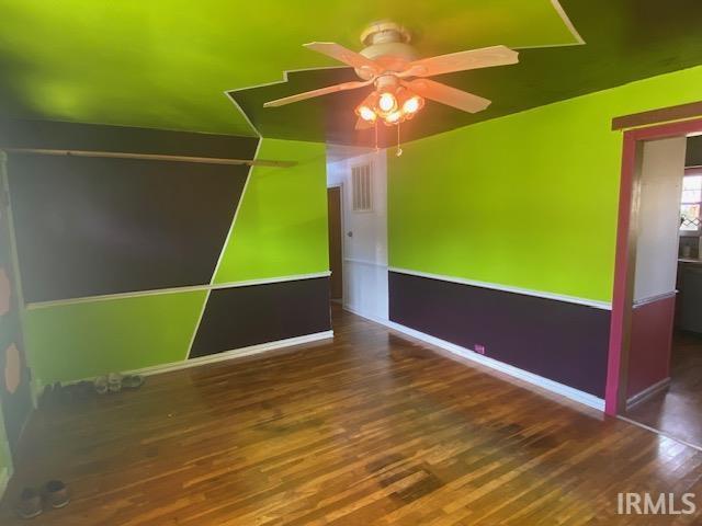 unfurnished room featuring wood finished floors, a ceiling fan, and baseboards