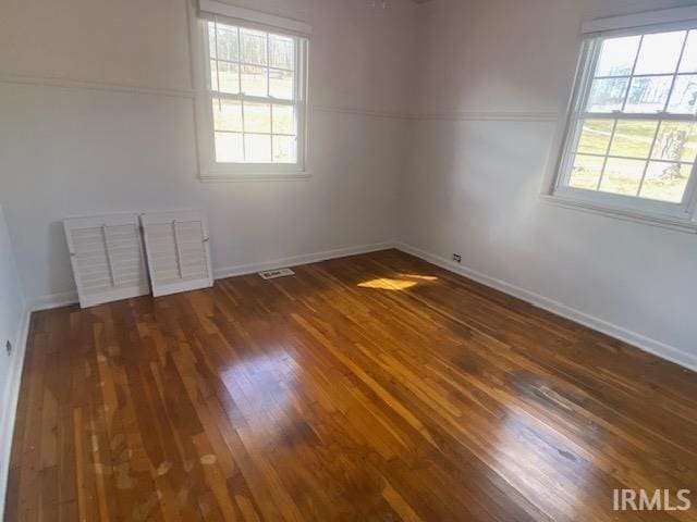 empty room with baseboards and wood finished floors