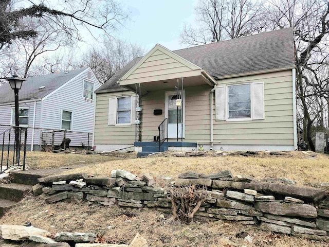 bungalow-style house with fence and roof with shingles