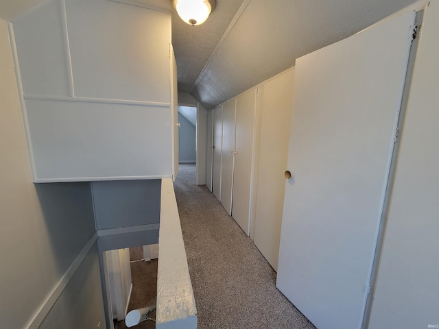 hall with vaulted ceiling and light carpet