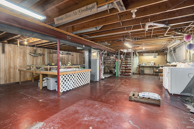 unfinished basement featuring a workshop area, stairway, and washing machine and clothes dryer