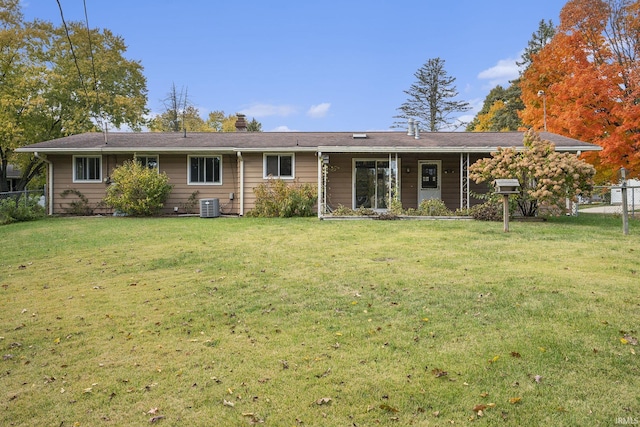 back of house featuring central AC unit, a lawn, and fence