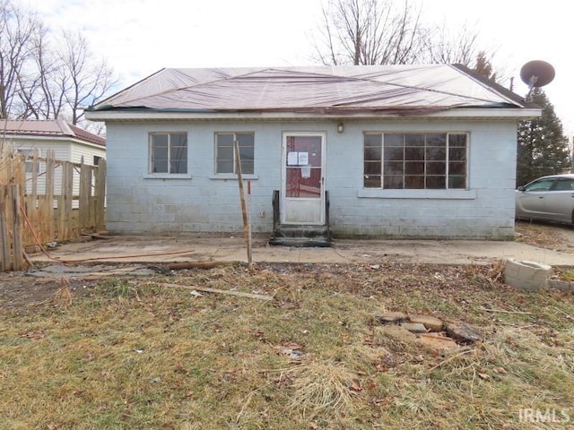 view of front facade featuring fence and concrete block siding