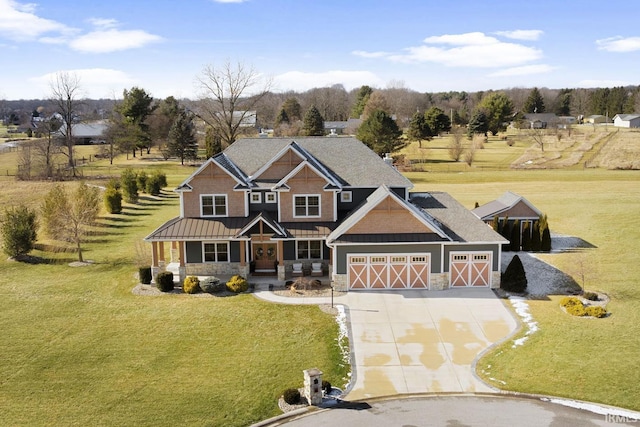 craftsman-style house featuring a porch, a front yard, a standing seam roof, stone siding, and driveway