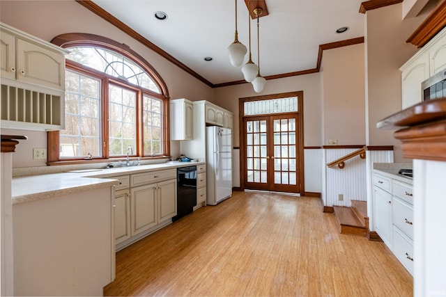 kitchen with black dishwasher, light wood-style flooring, freestanding refrigerator, light countertops, and french doors