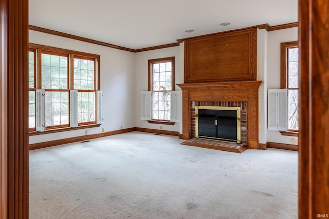 unfurnished living room featuring carpet, a brick fireplace, crown molding, and baseboards