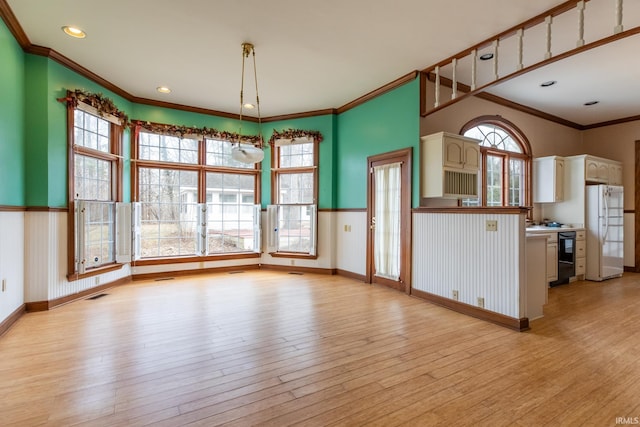 kitchen with light wood-style floors, freestanding refrigerator, and baseboards