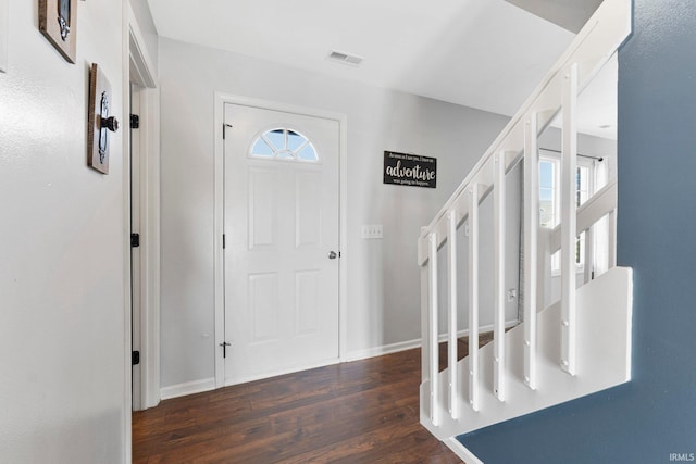 entryway with stairs, visible vents, baseboards, and wood finished floors