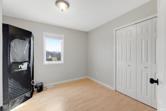 bedroom featuring a closet, baseboards, and wood finished floors