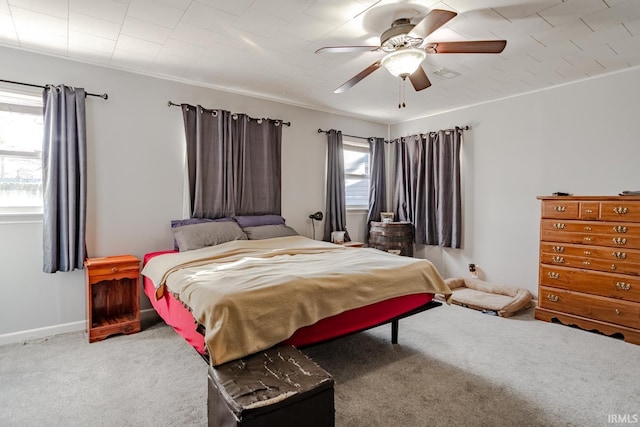 carpeted bedroom featuring a ceiling fan, visible vents, ornamental molding, and baseboards