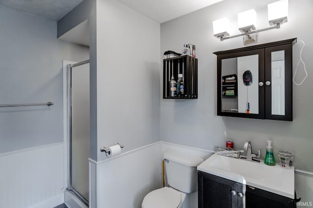 full bath featuring toilet, a shower stall, and vanity