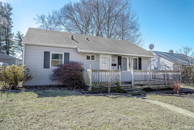 view of front of home featuring a shingled roof and a front yard