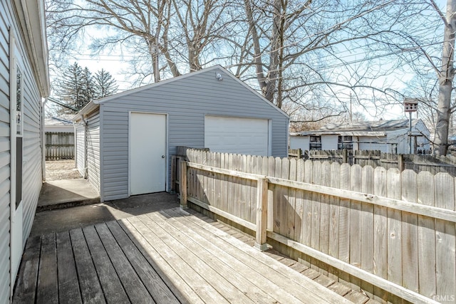 wooden deck featuring an outbuilding, fence, and a garage