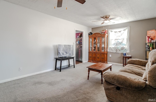 carpeted living room featuring baseboards and a ceiling fan