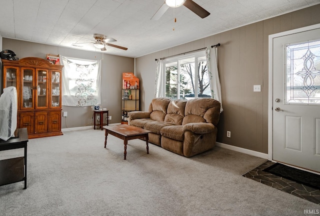 carpeted living room featuring ceiling fan and baseboards