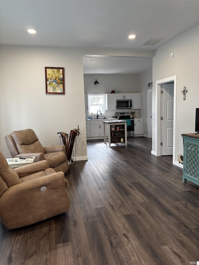 living room featuring baseboards, visible vents, dark wood finished floors, and recessed lighting