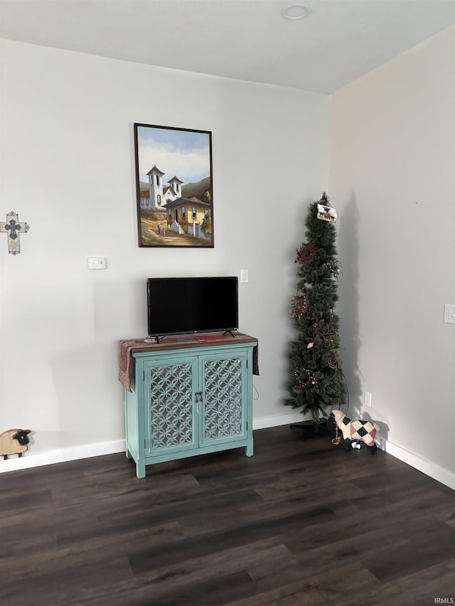 unfurnished living room featuring wood finished floors and baseboards