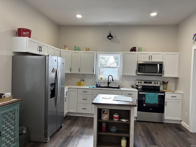 kitchen featuring tasteful backsplash, dark wood-type flooring, stainless steel appliances, open shelves, and a sink