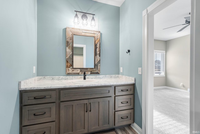 bathroom with ceiling fan, vanity, and baseboards