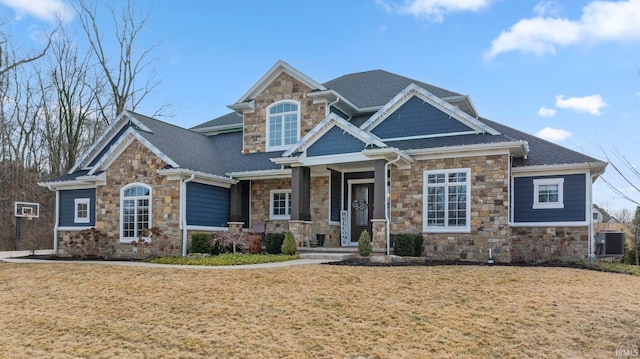 craftsman house featuring a front yard, cooling unit, and roof with shingles