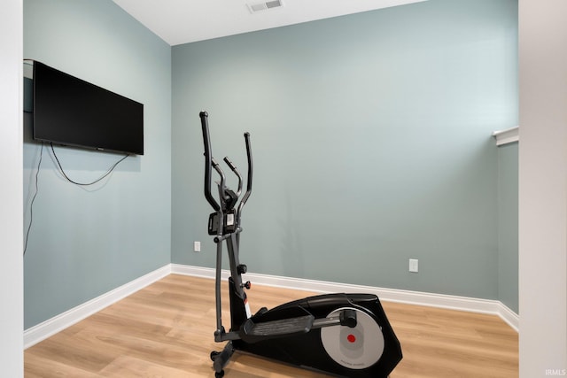 exercise room featuring light wood-type flooring, visible vents, and baseboards