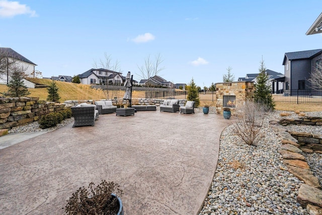 view of patio / terrace featuring fence and an outdoor living space with a fireplace