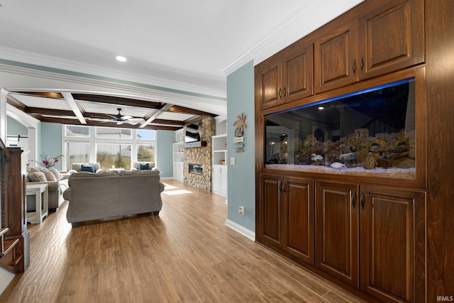 living area featuring coffered ceiling, ceiling fan, wood finished floors, beamed ceiling, and a fireplace