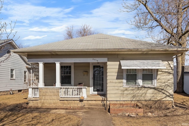 bungalow featuring a porch and roof with shingles