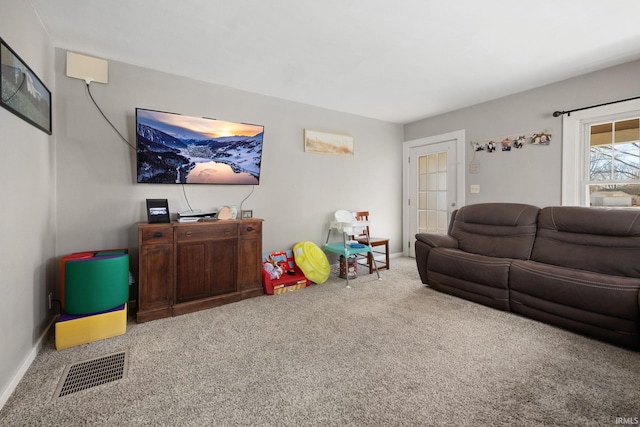 carpeted living room featuring visible vents and baseboards