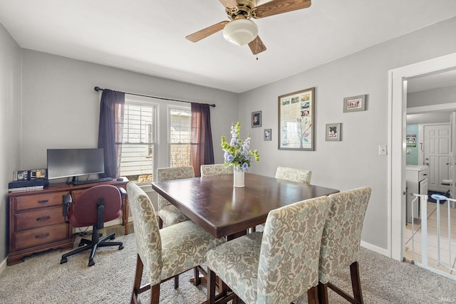 carpeted dining area with ceiling fan and baseboards