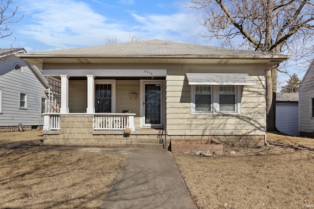 bungalow featuring covered porch and roof with shingles