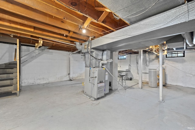 basement with heating unit, stairs, and a sink