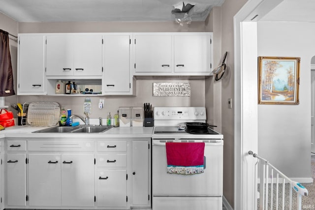 kitchen with light countertops, electric range, a sink, and white cabinets