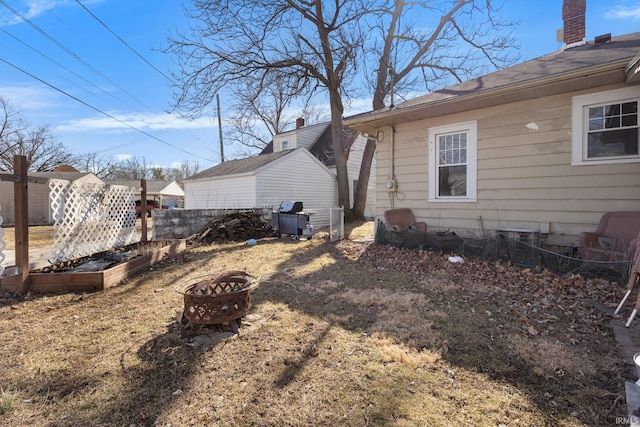 exterior space featuring a vegetable garden, a chimney, and a fire pit