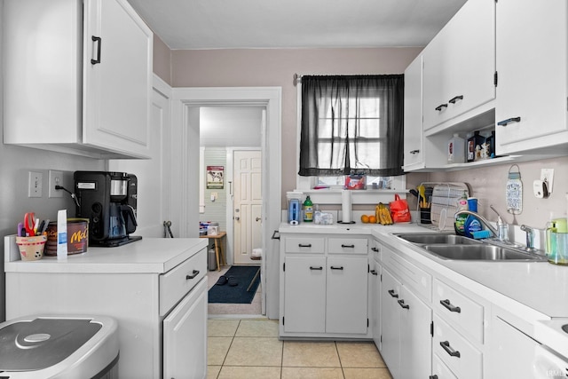 kitchen featuring light countertops, a sink, and white cabinetry