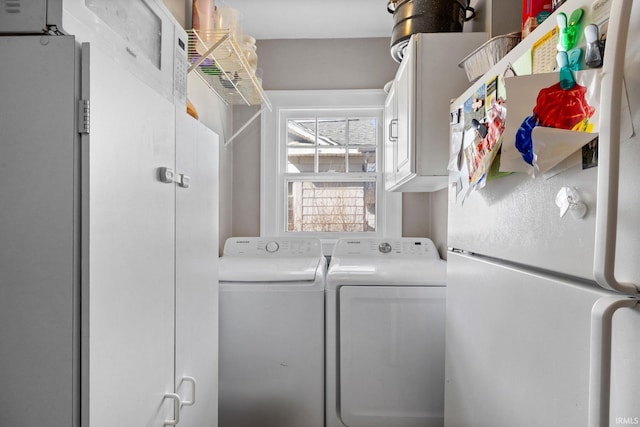 washroom featuring cabinet space and independent washer and dryer