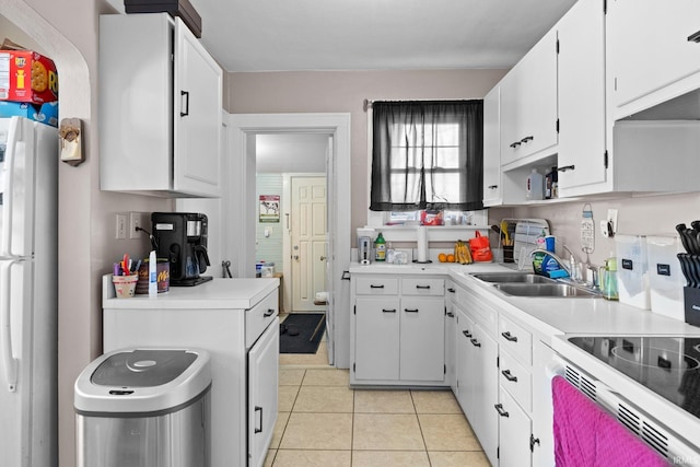 kitchen featuring light tile patterned floors, white appliances, a sink, white cabinetry, and light countertops