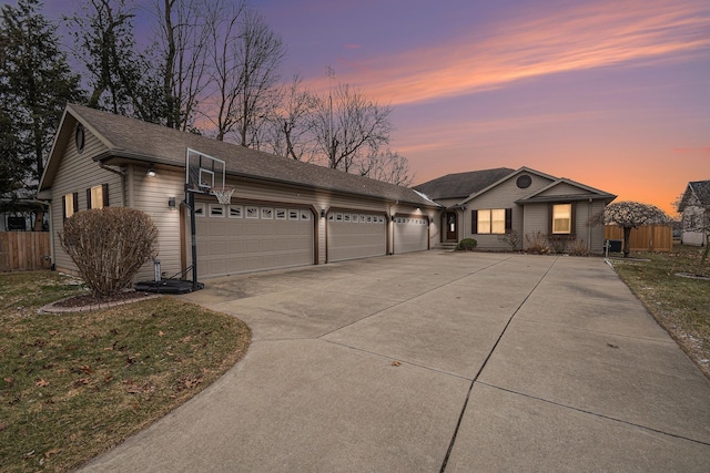 single story home with driveway, an attached garage, and fence