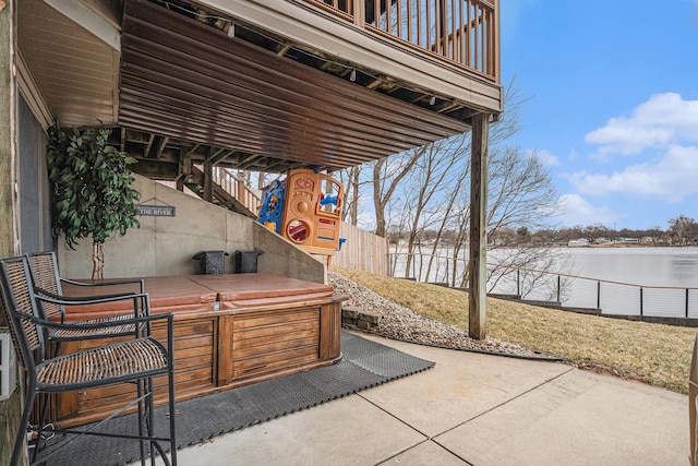 view of patio / terrace with a water view and fence