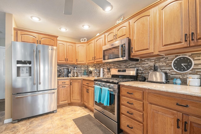 kitchen with a textured ceiling, stainless steel appliances, tasteful backsplash, and a ceiling fan