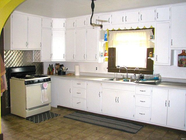 kitchen featuring a sink, white cabinets, white range with gas cooktop, light countertops, and tasteful backsplash