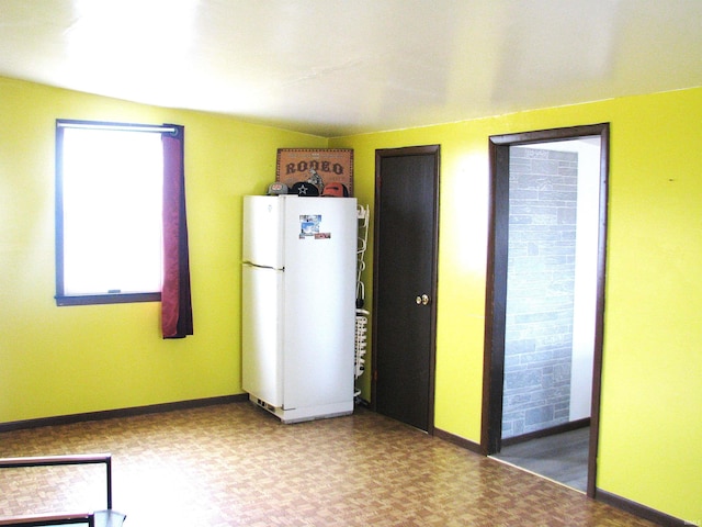 kitchen featuring freestanding refrigerator and baseboards