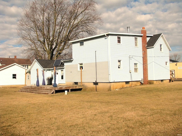 rear view of house featuring a deck and a yard