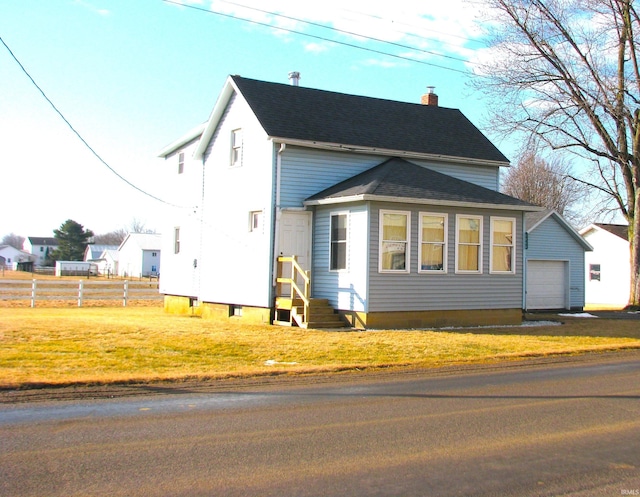 view of side of home with entry steps, a lawn, a chimney, roof with shingles, and fence