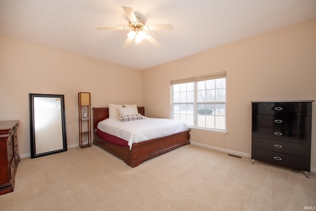 bedroom with a ceiling fan, light carpet, visible vents, and baseboards