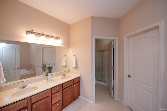 full bath with double vanity, a sink, a bath, and tile patterned floors