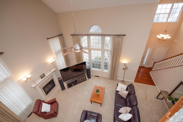 carpeted living area featuring a tile fireplace, visible vents, and a towering ceiling