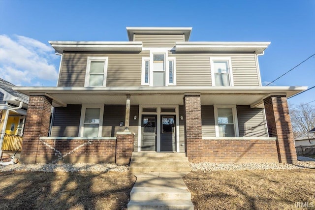 view of front of property with covered porch and brick siding