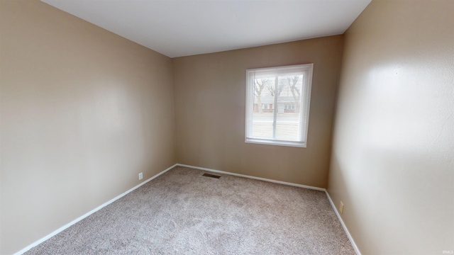 carpeted empty room featuring visible vents and baseboards